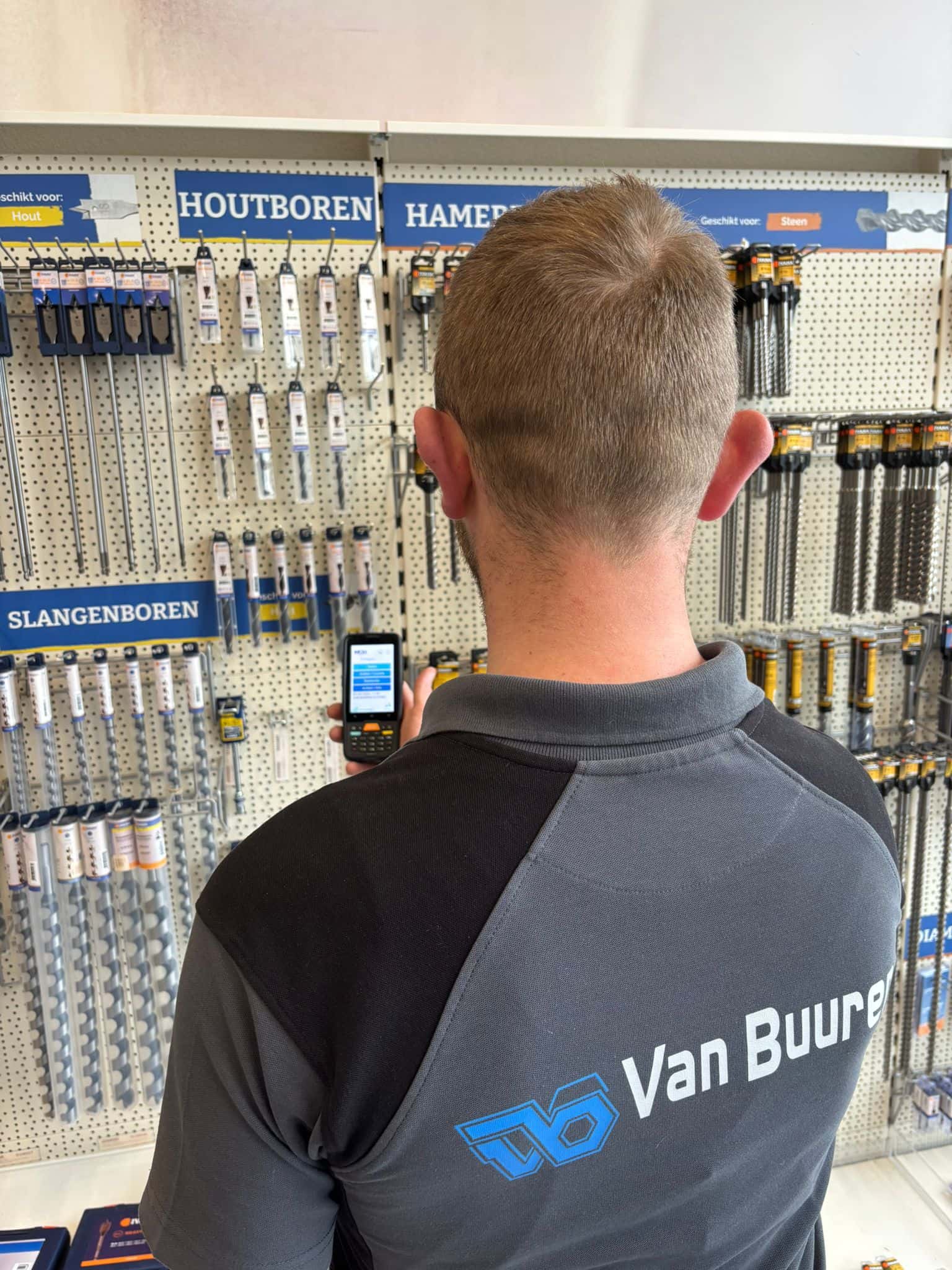 Winkelmedewerker scant een artikel aan het schap met de MSG winkel scan-app