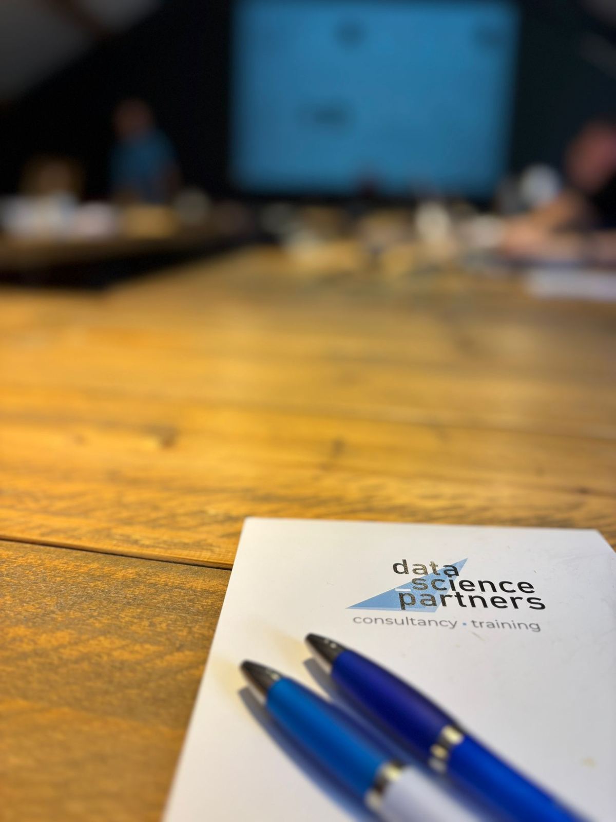 Notitieblok en pennen van Data Science Partners op de vergadertafel tijdens de training